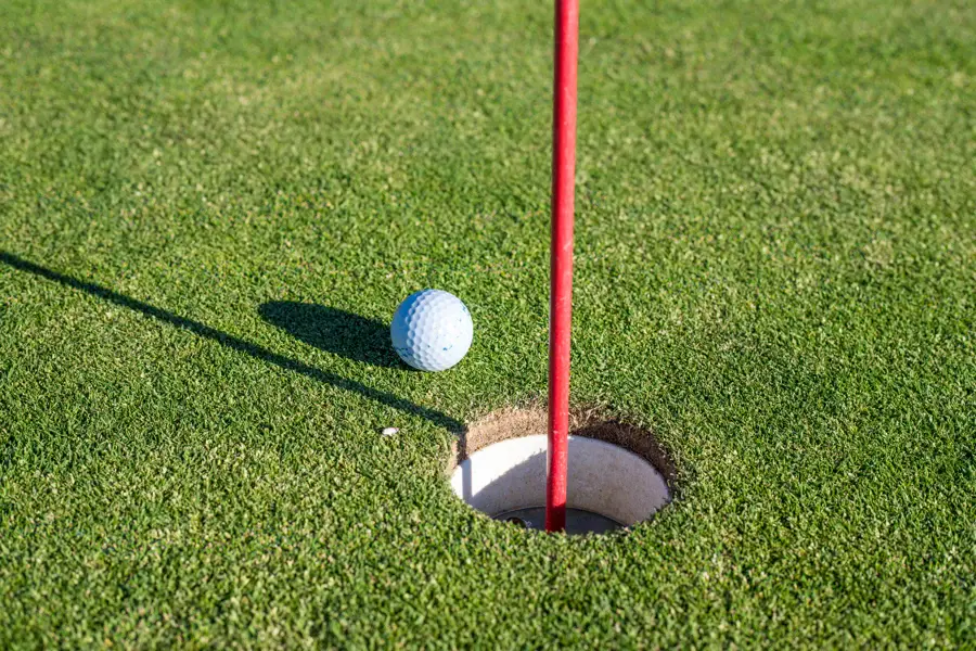 Balle de golf près du drapeau sur un green