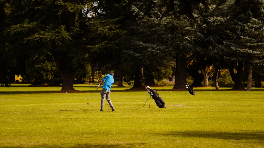 Golfeur au sommet du backswing sur un parcours